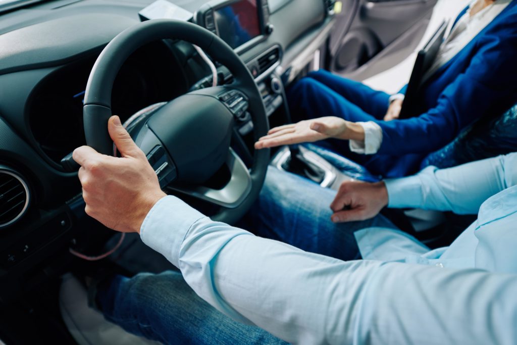 salesperson showing someone a car in car sales