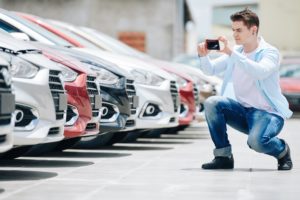 man picturing cars for car dealership social media marketing